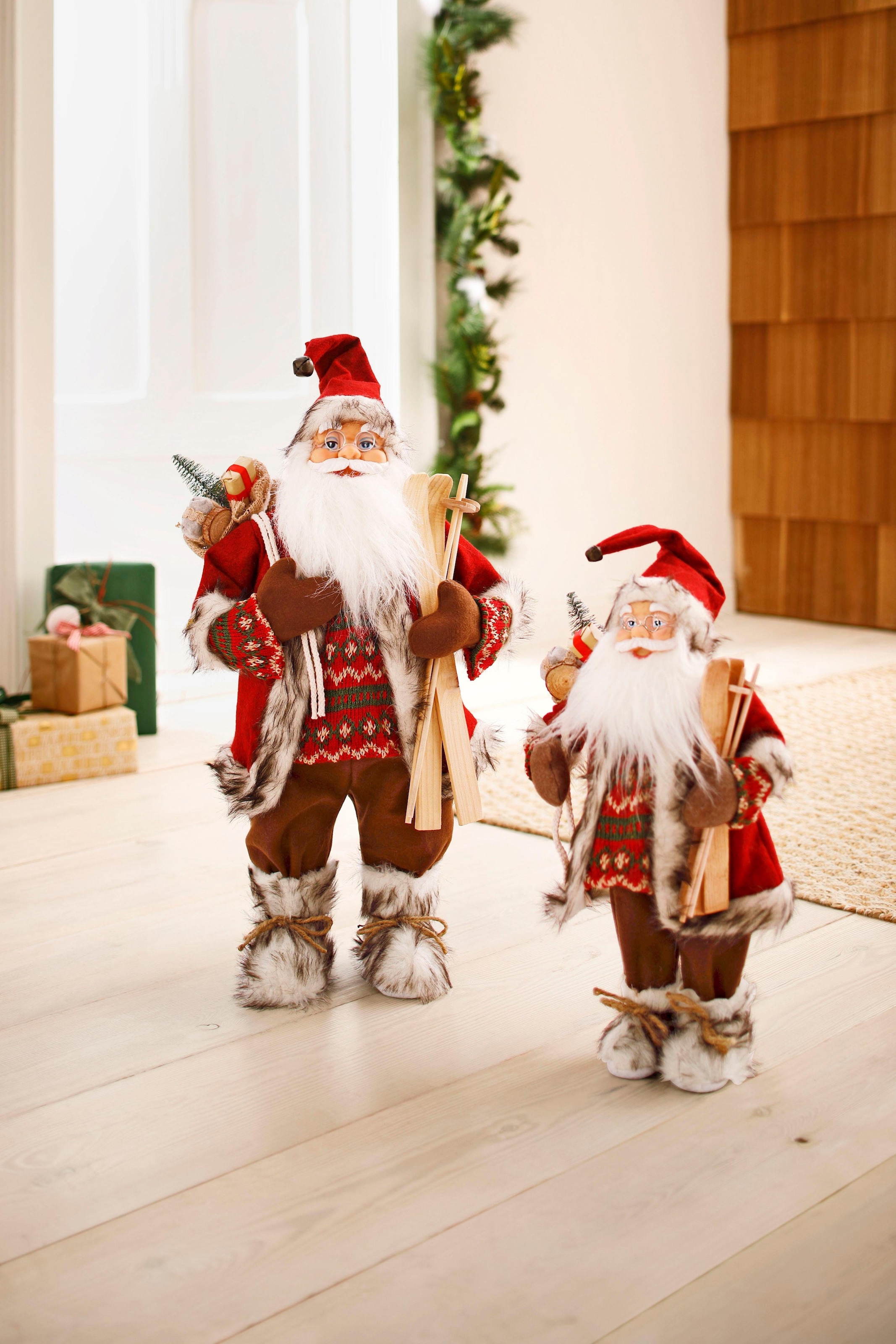 bei unter dem Skiern Geschenken«, - HOSSNER Weihnachtsfigur und Weihnachtsdeko, »Santa mit online OTTO Weihnachtsmann Dekofigur, HOMECOLLECTION Arm