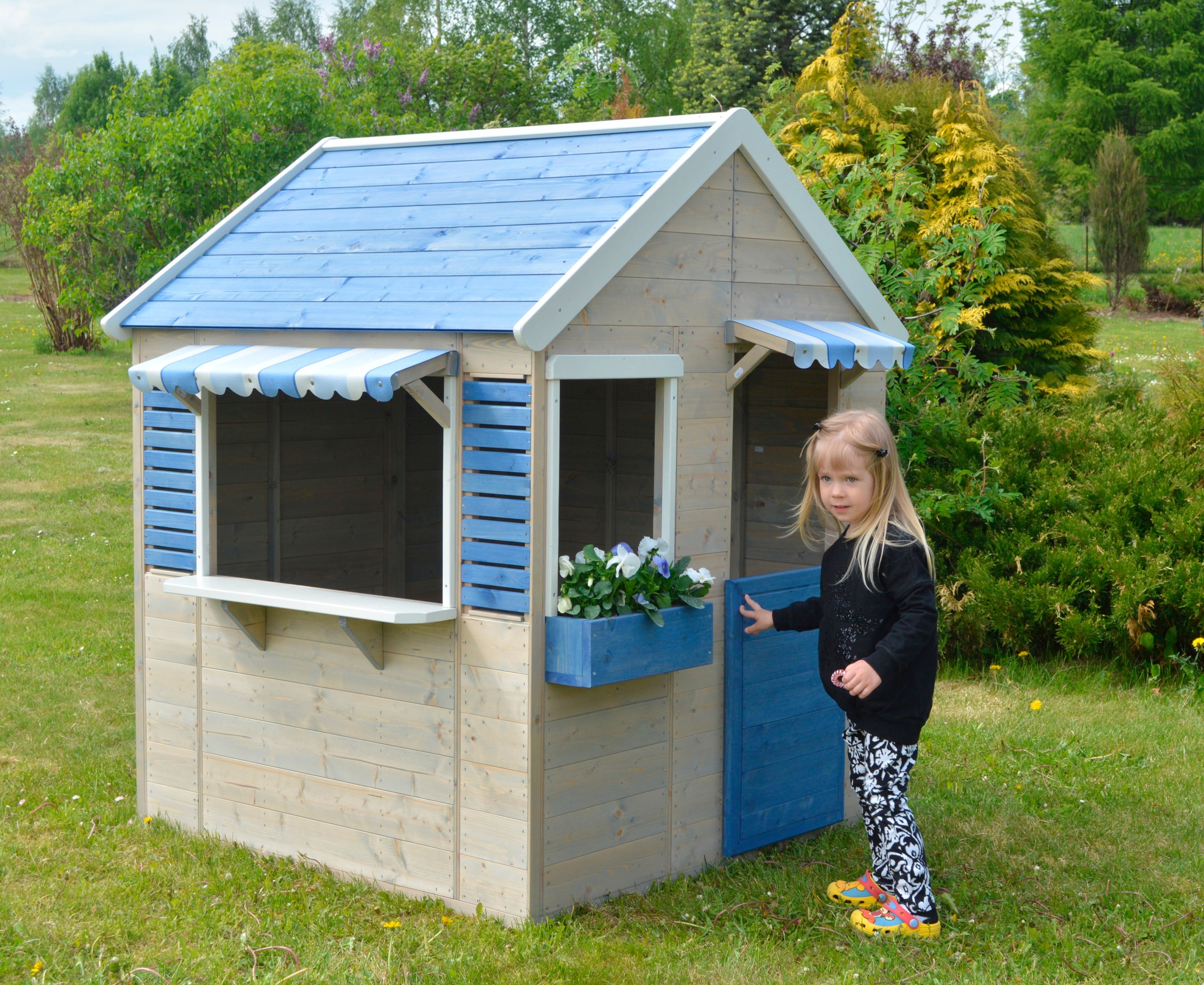 Spielhaus aus Holz mit blauem Dach, Fensterbalken und Blumenkasten